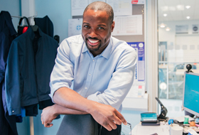 Photo of African American man standing inside of his office.